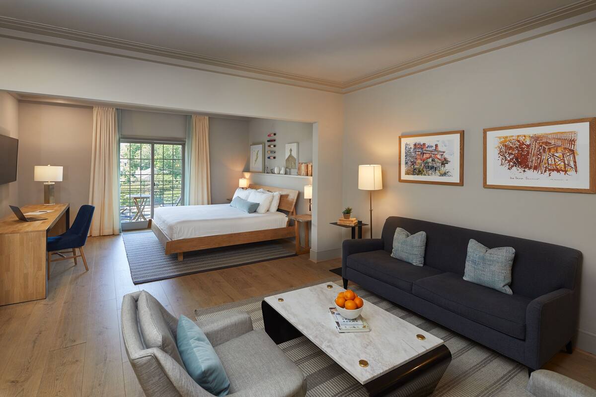 Une chambre d’hôtel moderne équipée d’un lit, d’un canapé, d’un bureau et d’un coin repas.