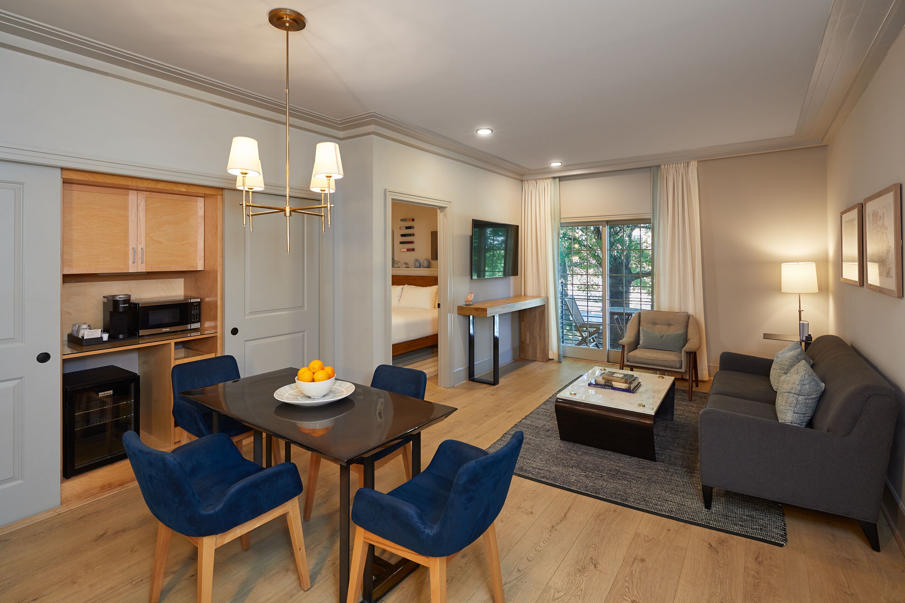 Een moderne woonkamer met een bank, een salontafel en een eethoek met een tafel en stoelen.