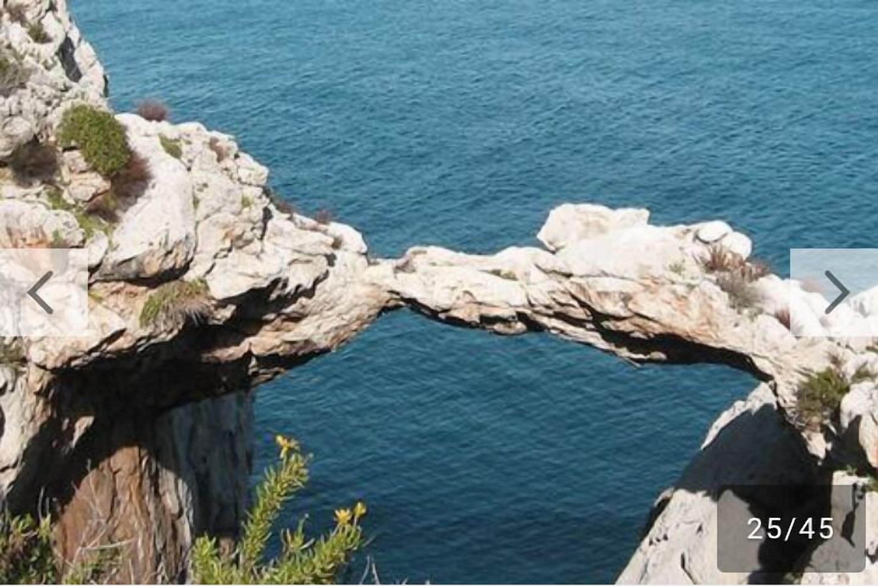 Formação rochosa natural com uma passagem estreita sobre a água.