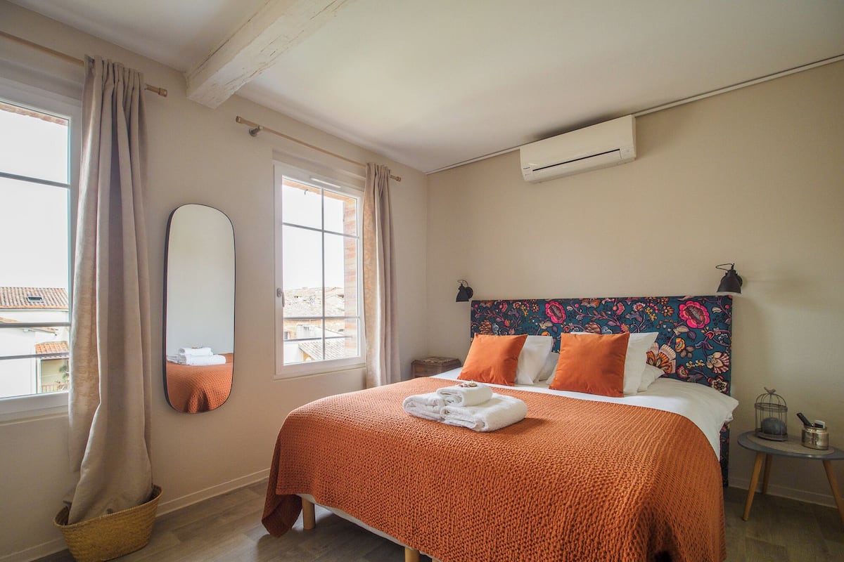 Une chambre d’hôtel équipée d’un lit, d’une fenêtre, d’un miroir et d’un appareil de climatisation.