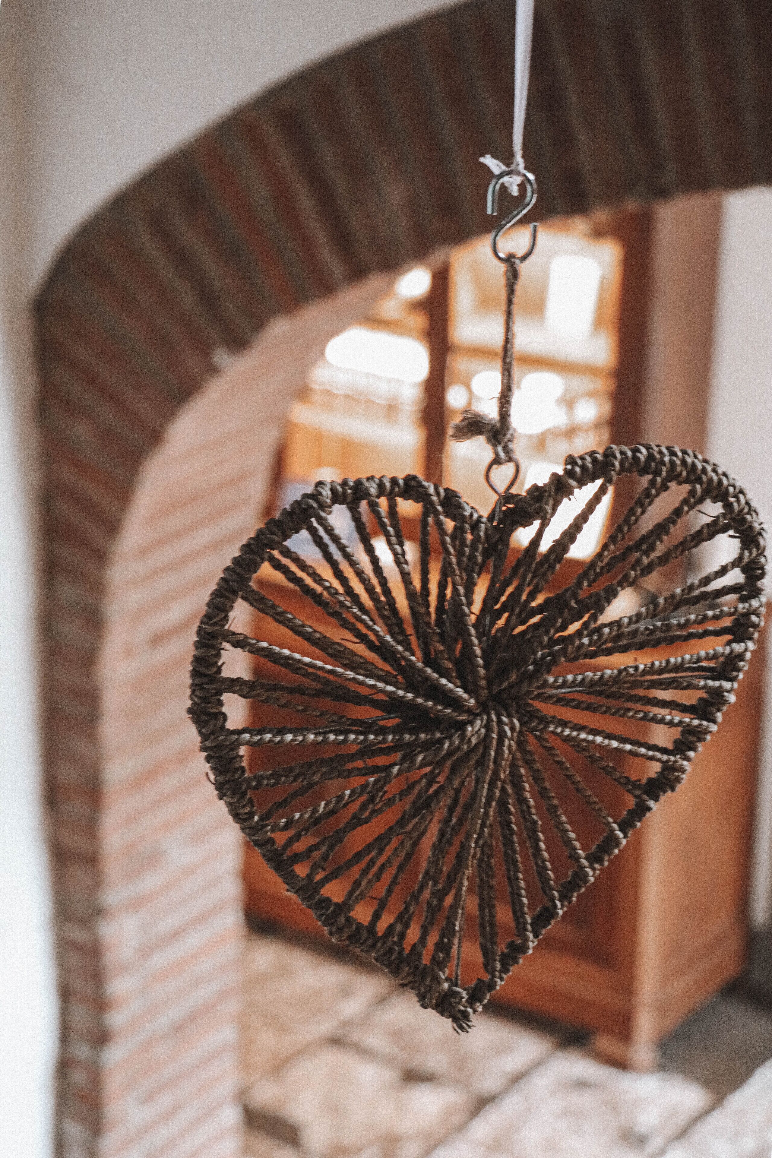 Un adorno colgante de macramé con forma de corazón.
