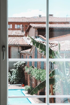 Guests can enjoy views of a residential area with a swimming pool from the comfort of their room.