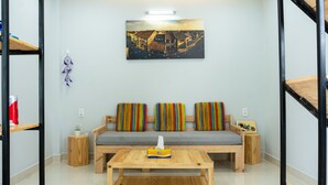 A cozy living room with a sofa, a coffee table, and a painting on the wall. - Facetime Home (Da Nang)