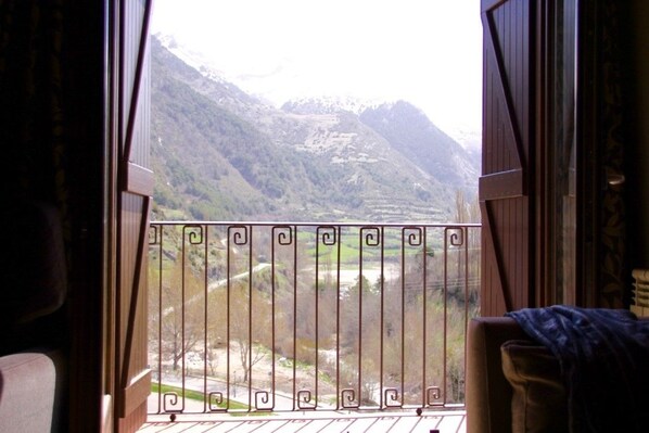 A balcony with a wrought iron railing overlooking a mountainous landscape. - Aparthotel Tres Quiñones (Sallent de Gallego)