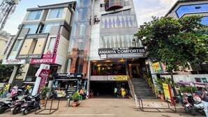 Un bâtiment moderne orné de nombreuses enseignes indiquant des hôtels et des commerces, notamment « ABHIRUCHI HOTEL » et « ANANYA COMFORTSS ».
