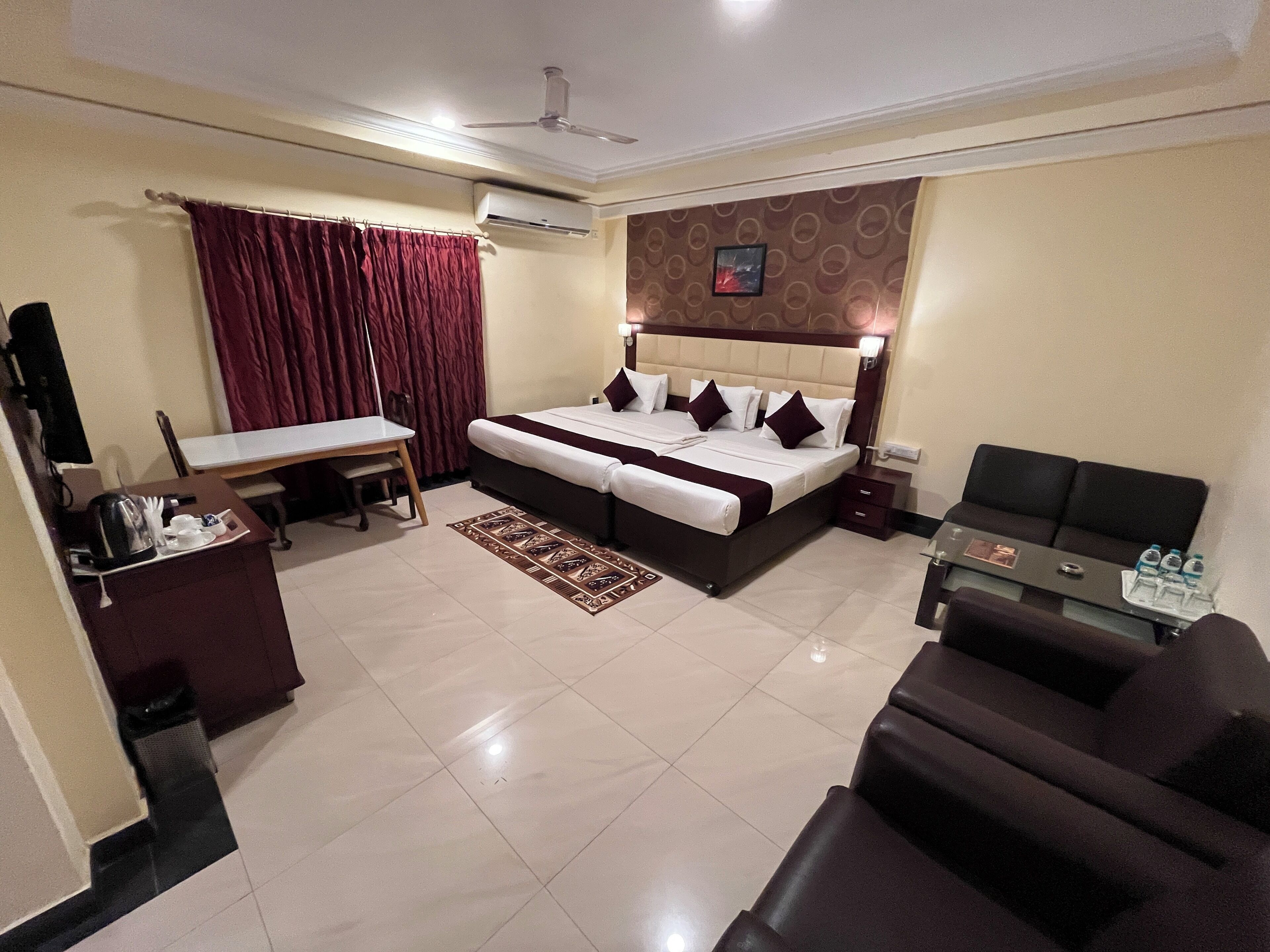 Een hotelkamer met een bed, een bureau, een stoel, een bank en een airconditioning.