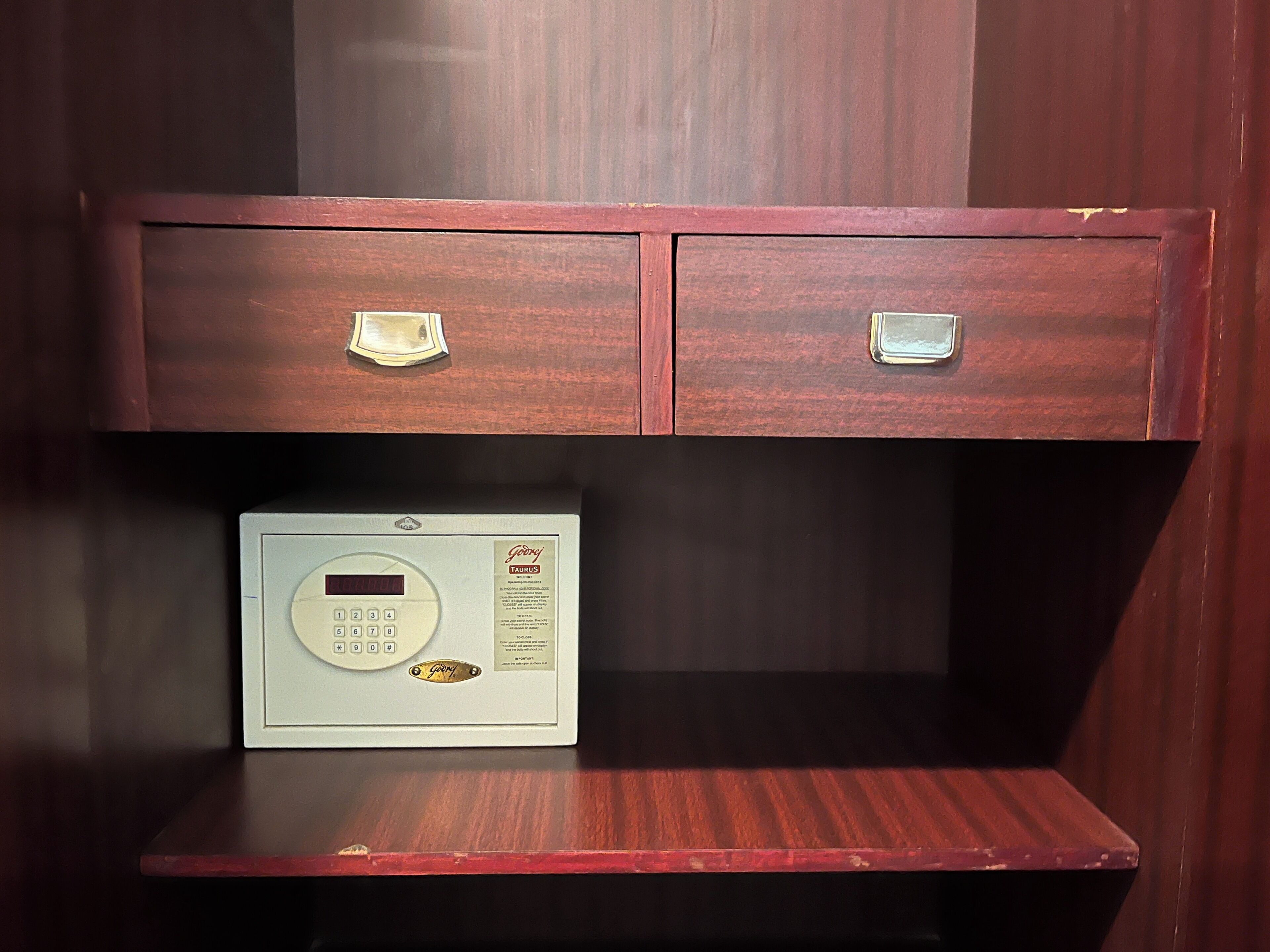 Un mueble de madera con dos cajones y una balanza sobre una repisa de madera.