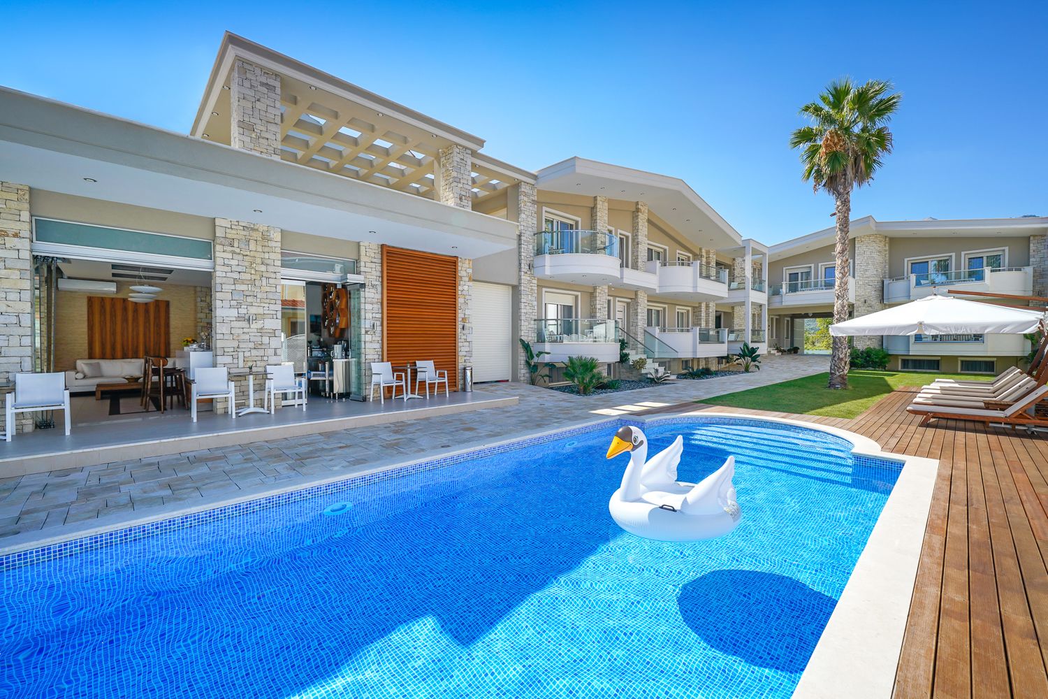 A modern hotel with a swimming pool featuring a swan float.