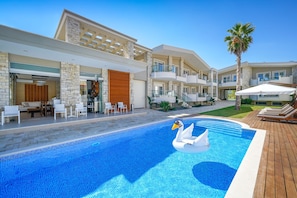 A modern hotel with a swimming pool featuring a swan float. - Lobelia Luxury Suites (Thasos)