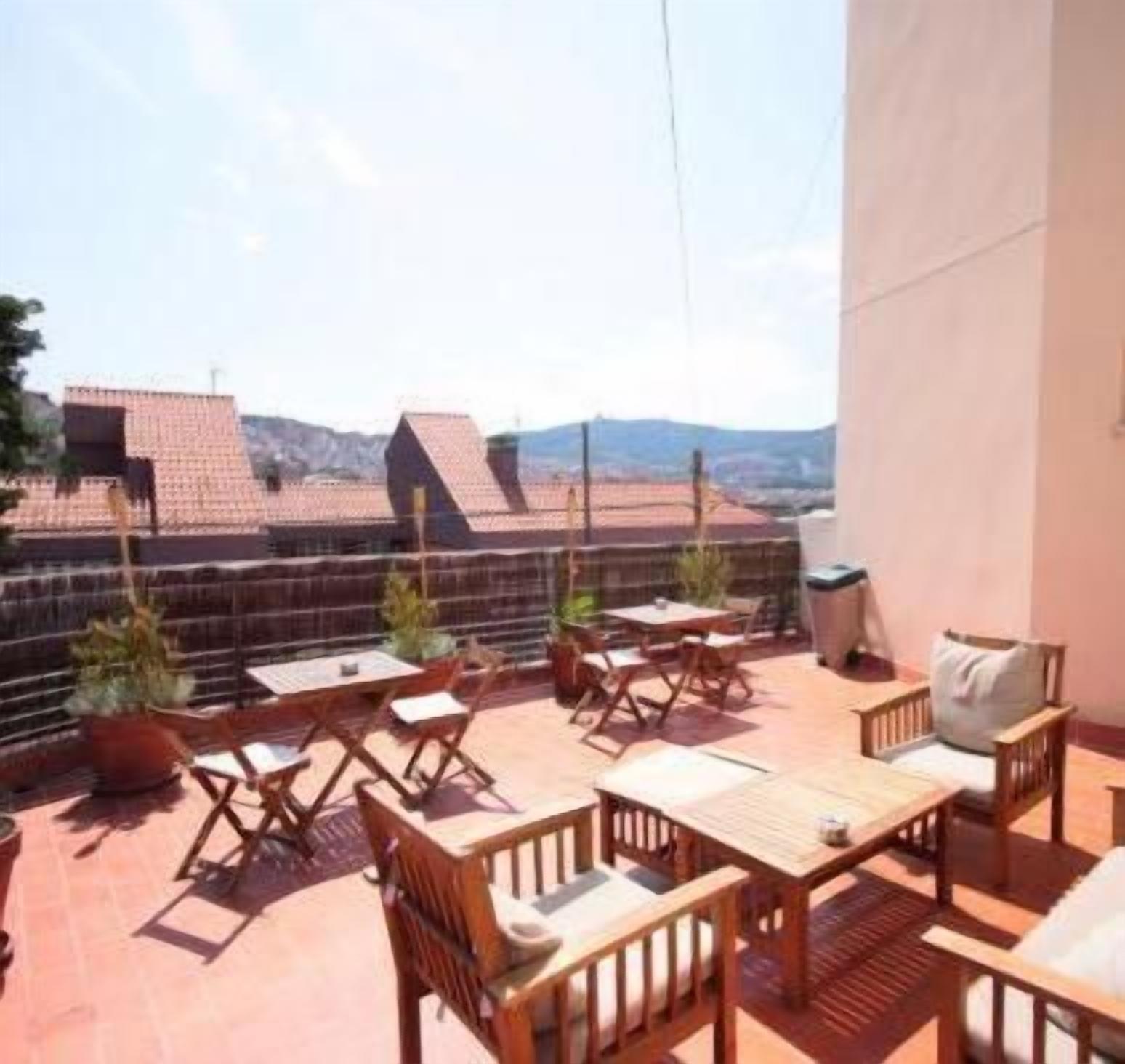 Una terraza con mobiliario exterior y vistas a edificios.