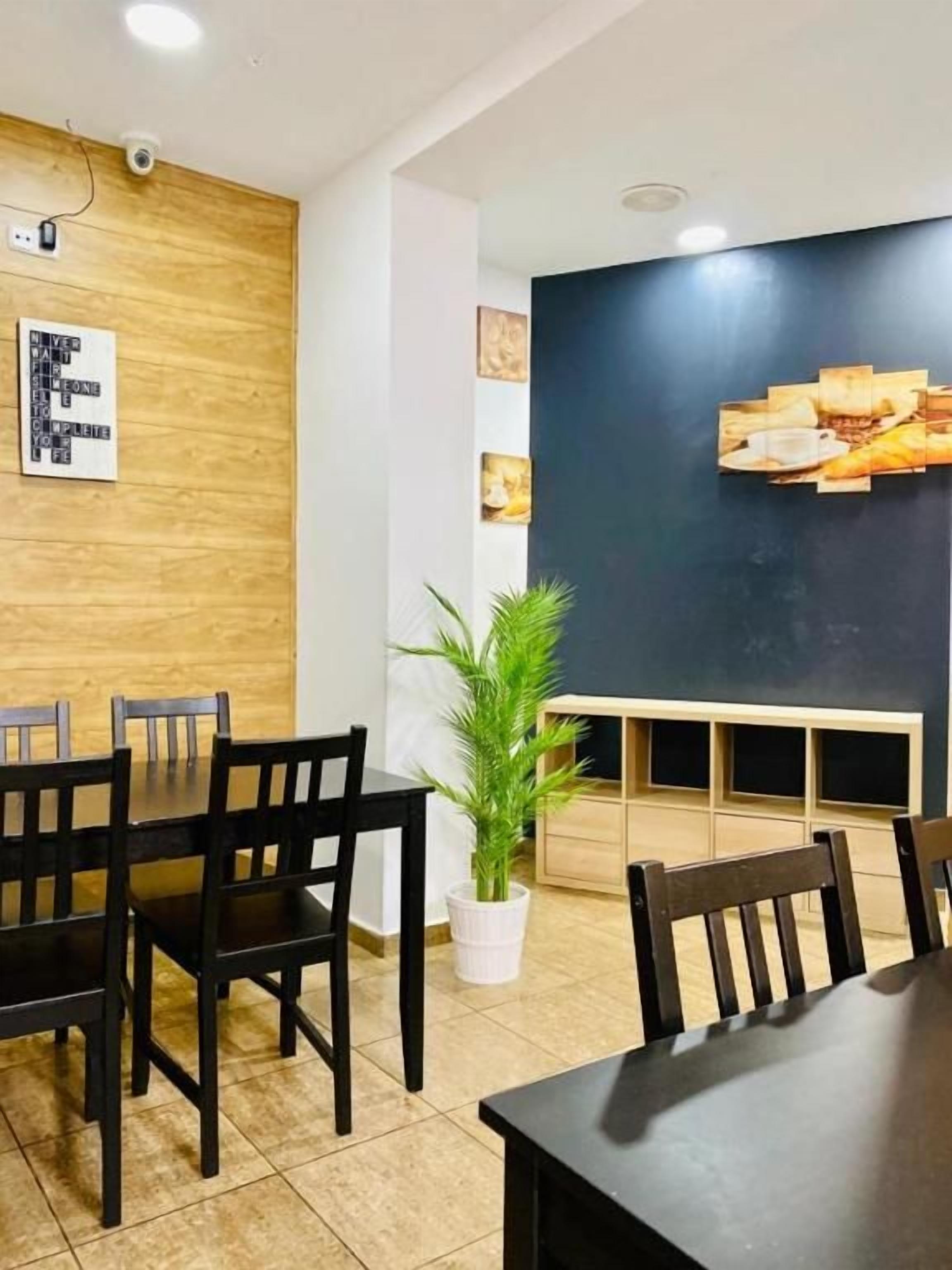 Une salle de conférence avec un mur en bois, une table noire et des chaises.