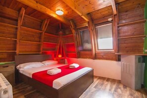 A wooden cabin bedroom with a bed, a heater, and a window. - Mellow Hostel Barcelona (Barcelona)