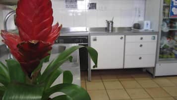 Una cocina con armarios blancos, un microondas y un lavamanos.