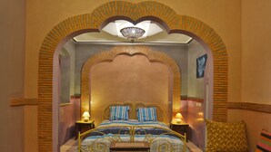 A room with a bed, a bench, and a small table. - Riad Aicha Marrakech (Marrakech)
