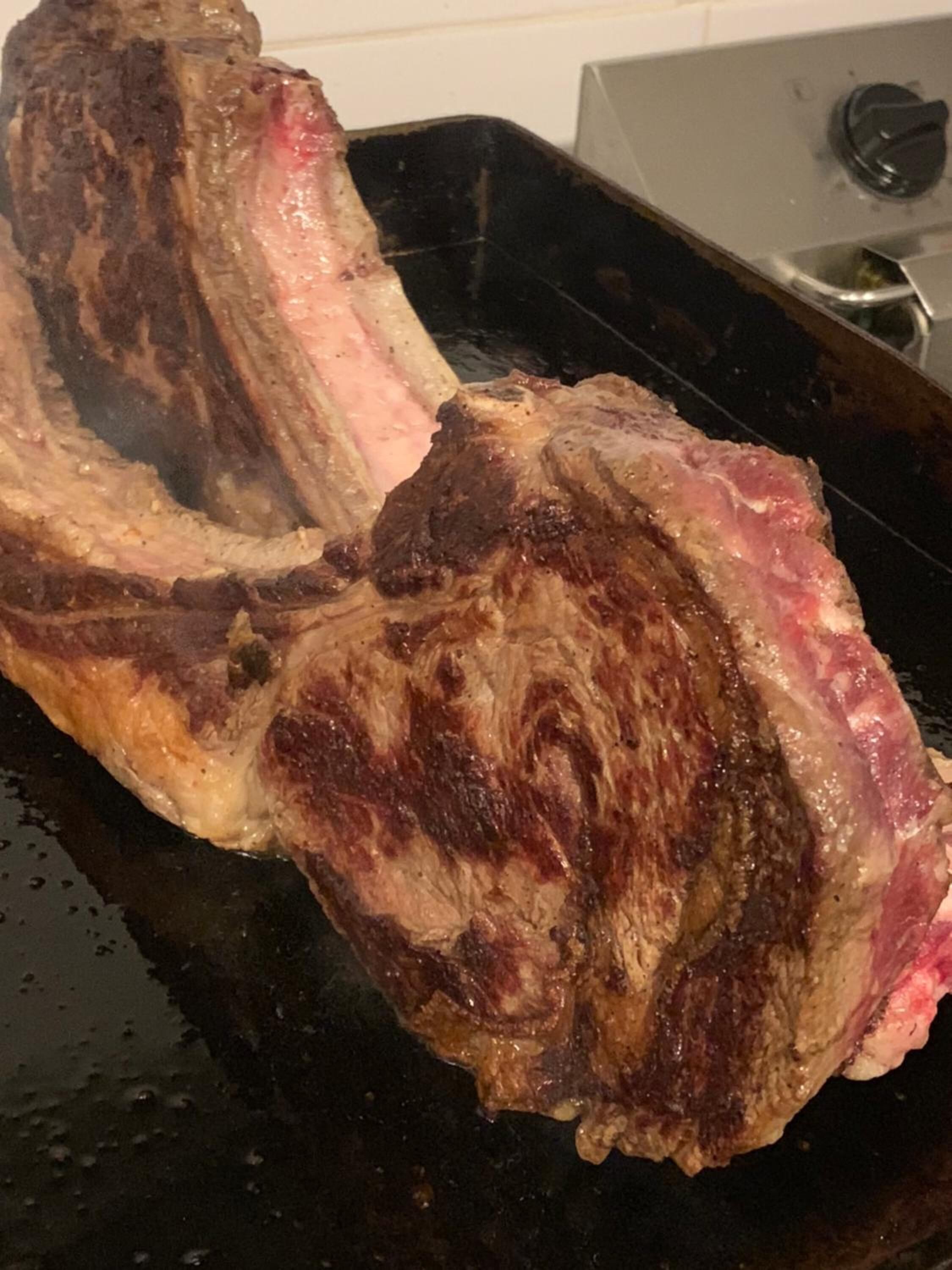 Un jugoso bistec cocinándose en una sartén.
