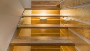 Una escala de fusta amb il·luminació integrada, que condueix a un pis superior.