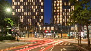 A modern hotel with a prominent 'NOVOTEL' sign, featuring a unique architectural design with a large central void and illuminated windows. - Novotel Ambassador Seoul Dongdaemun Hotels & Residences (Seoul)
