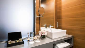 Un bagno moderno con uno specchio grande, un lavandino bianco e un mobile contenitore con ripiano per asciugamani.