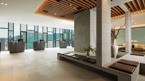A spacious lobby with a high ceiling, large windows, and a reception desk. - Novotel Ambassador Seoul Dongdaemun Hotels & Residences (Seoul)