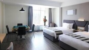 Une chambre d’hôtel avec un lit, un bureau et une chaise.