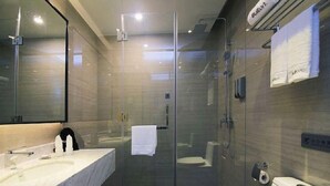 Une salle de bain moderne avec une douche à parois de verre, un lavabo en marbre et des toilettes.