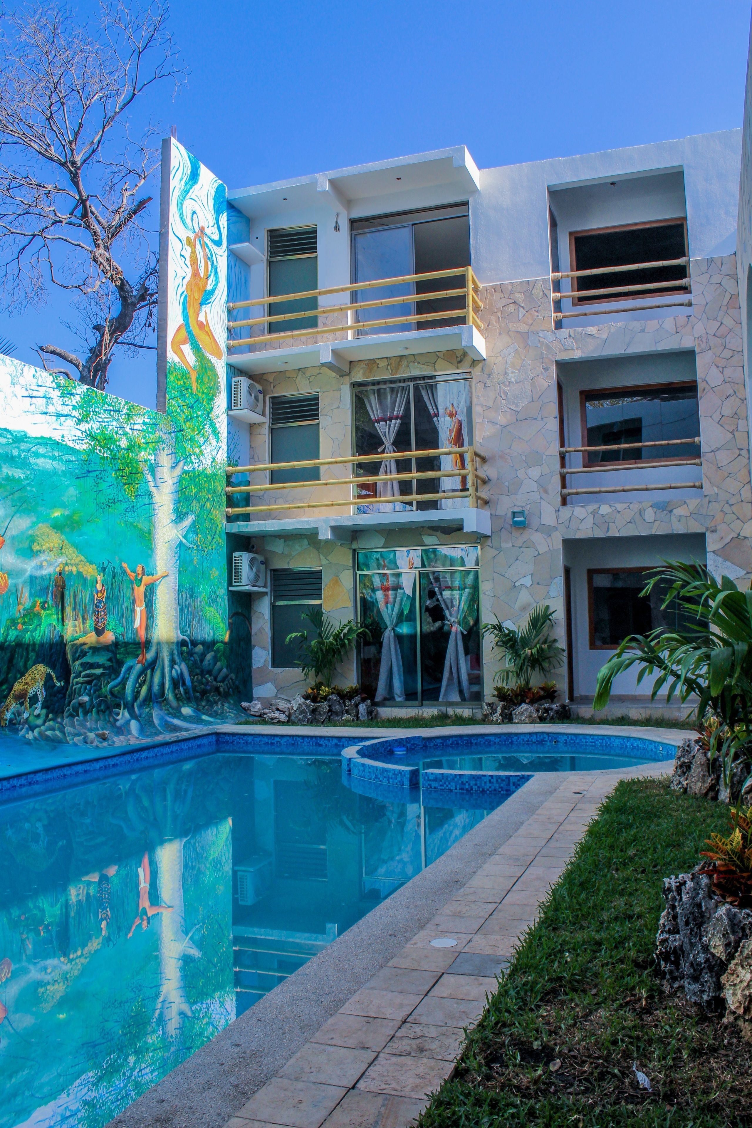 Un edificio moderno con piscina, un mural y un balcón.