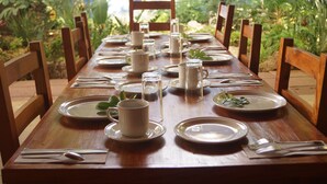 A dining table set with plates, cups, and cutlery, surrounded by chairs. - Axkan Arte Hotel Tuxtla (Tuxtla Gutierrez)
