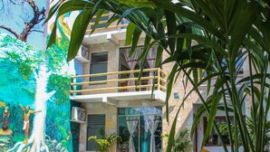 A modern building with a pool, surrounded by tropical plants. - Axkan Arte Hotel Tuxtla (Tuxtla Gutierrez)