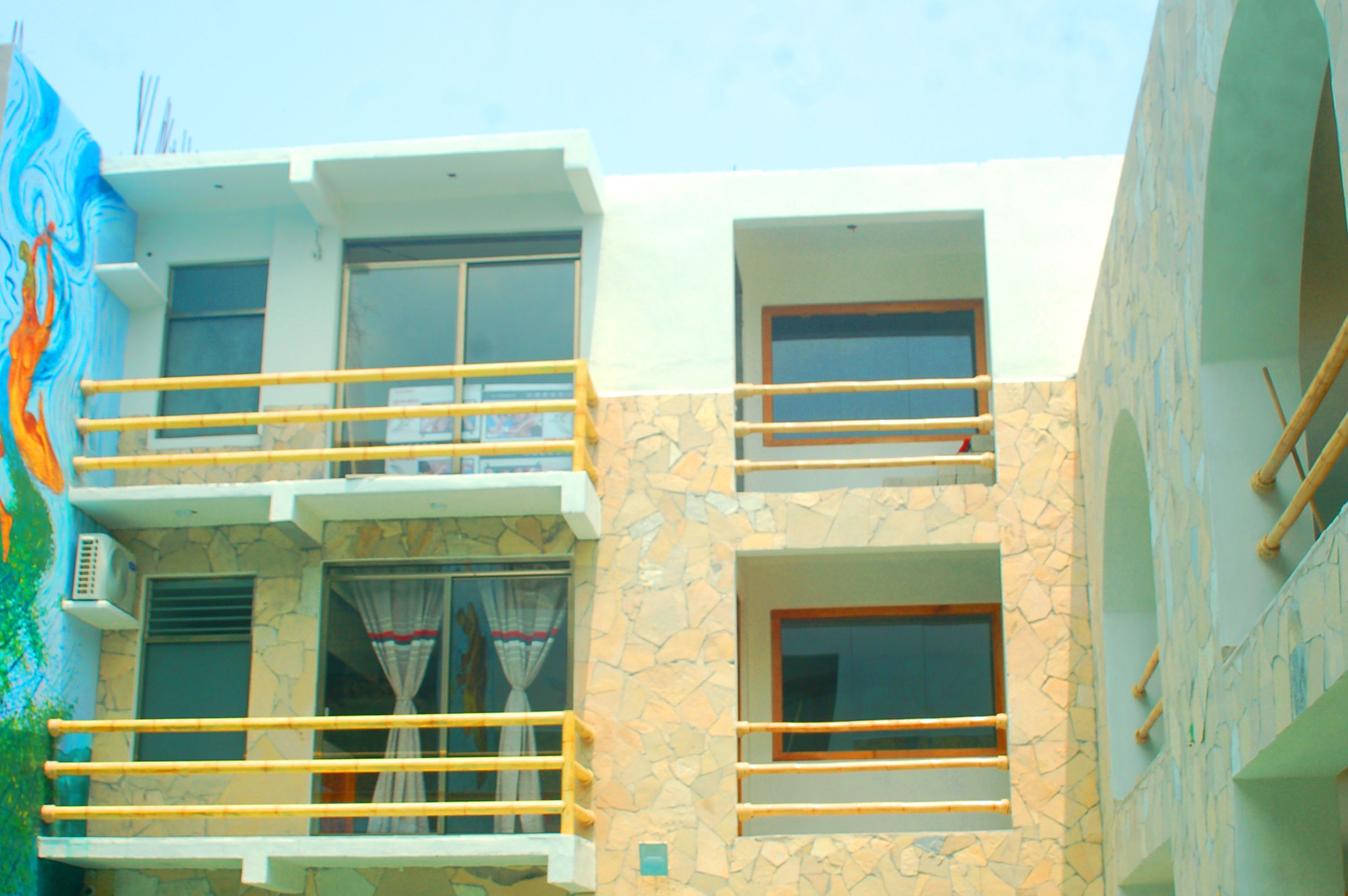 A multi-story building with balconies, stone facade, and multiple windows.