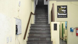 A staircase leading to a room with a sign reading "Hôtel Solar dos Romios" and a fire extinguisher on the wall. - Pousada Solar dos Romanos (Salvador)