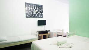 A hotel room with two single beds, a flat-screen TV mounted on the wall, and a small desk with a chair. - Pousada Solar dos Romanos (Salvador)