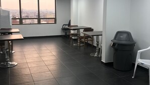 A modern office space with a large window, black and white ceiling design, and a trash bin. - Hotel Express 53 (Bogotá)