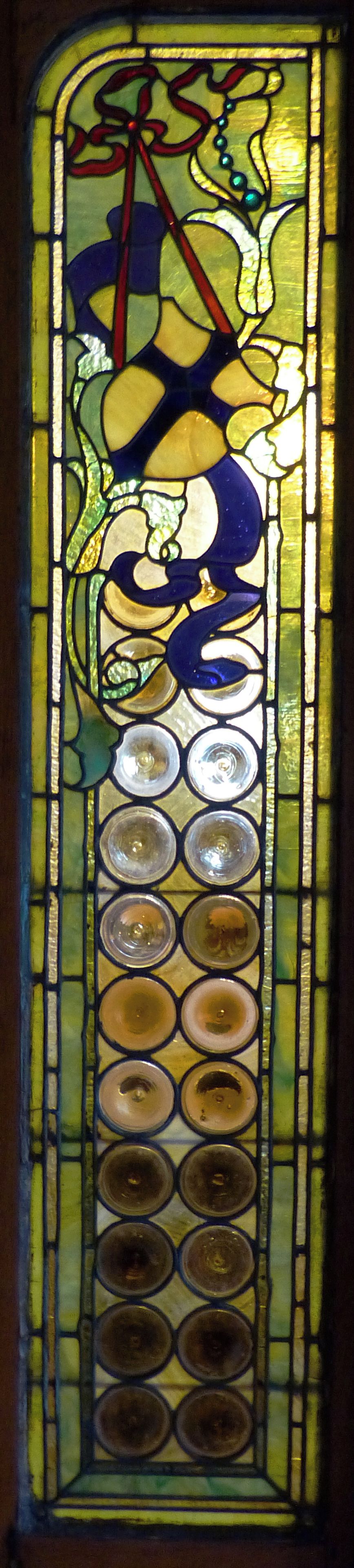 Una ventana de vitral con motivos florales y diseños circulares.
