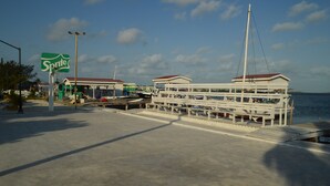 A docked boat with a white exterior and a red roof, a 'Sprite' sign, and a clear blue sky. - Ambergris Sunset Hotel (San Pedro)
