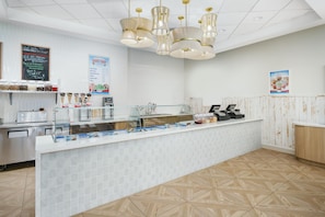 A clean, modern ice cream shop with a counter displaying various ice cream flavors and toppings. - Homewood Suites by Hilton Myrtle Beach Oceanfront (Myrtle Beach)