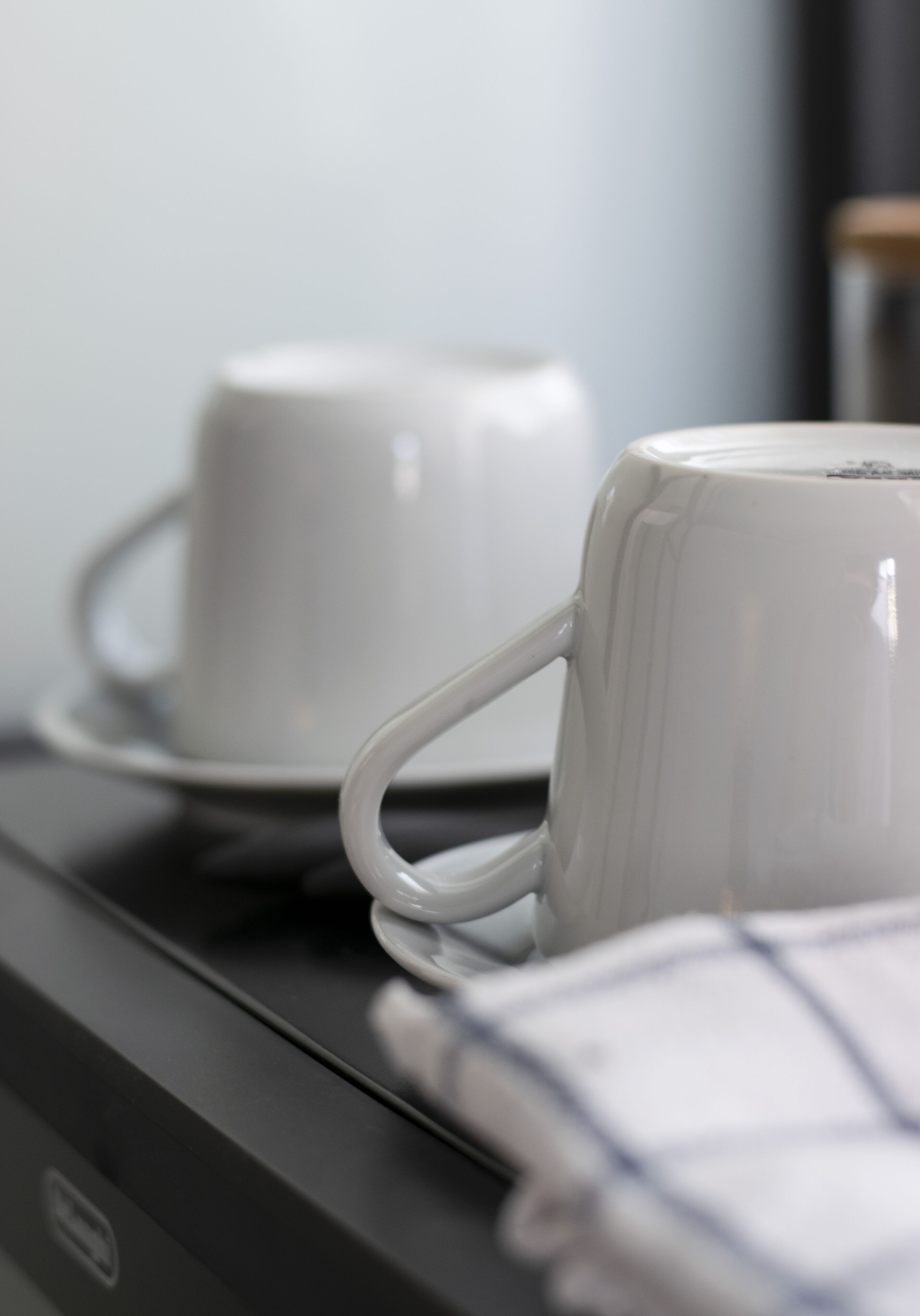 A white mug on a black surface, possibly a table or countertop.