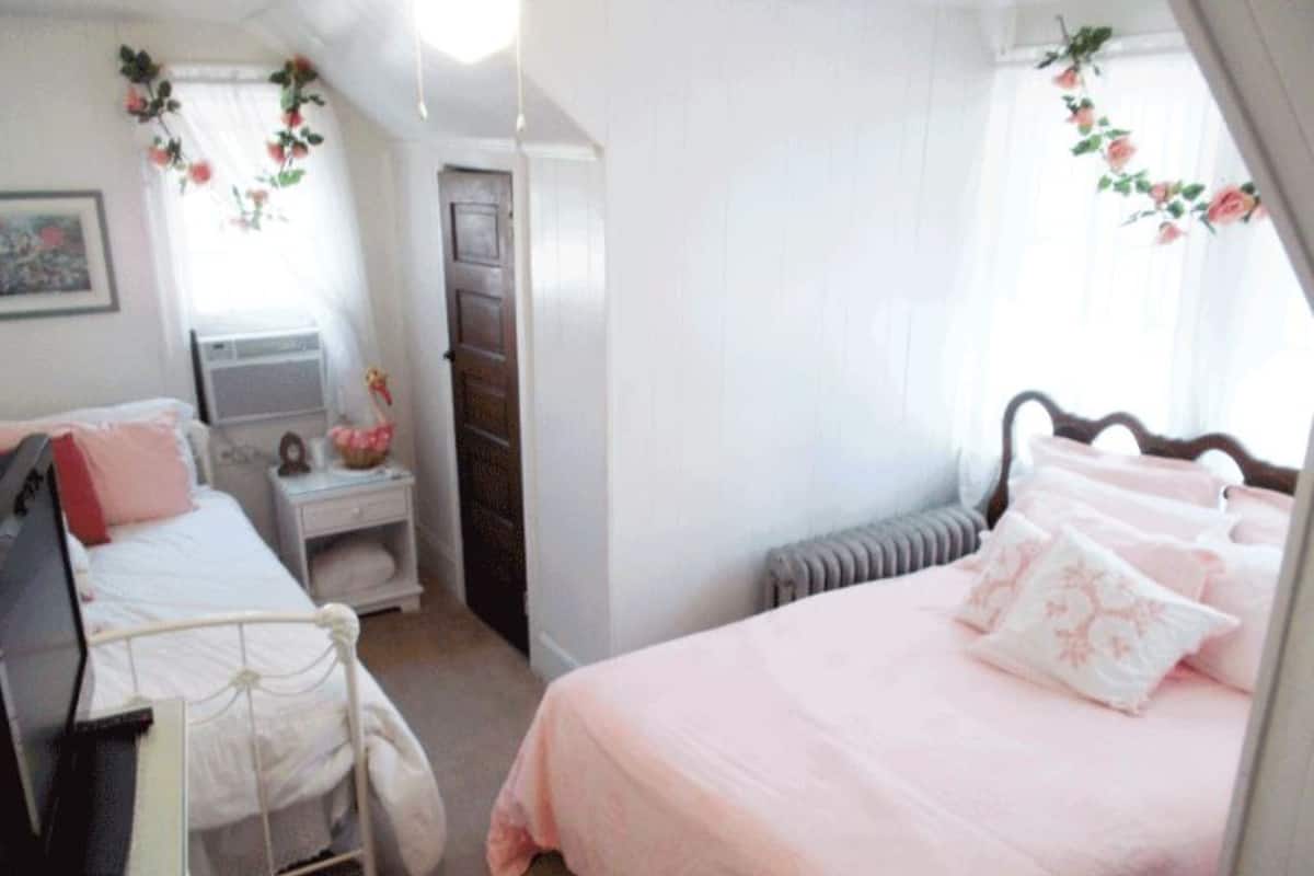 Une chambre à coucher comprenant un lit, une table de chevet, une commode et un radiateur.