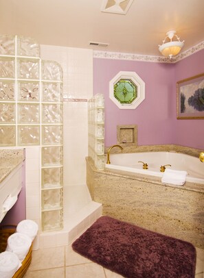 Een aparte badkuip en douche, een bubbelbad, een haardroger, badjassen