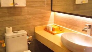 A modern bathroom with a toilet, sink, and mirror. - West Lake Hotel (Shenzhen)