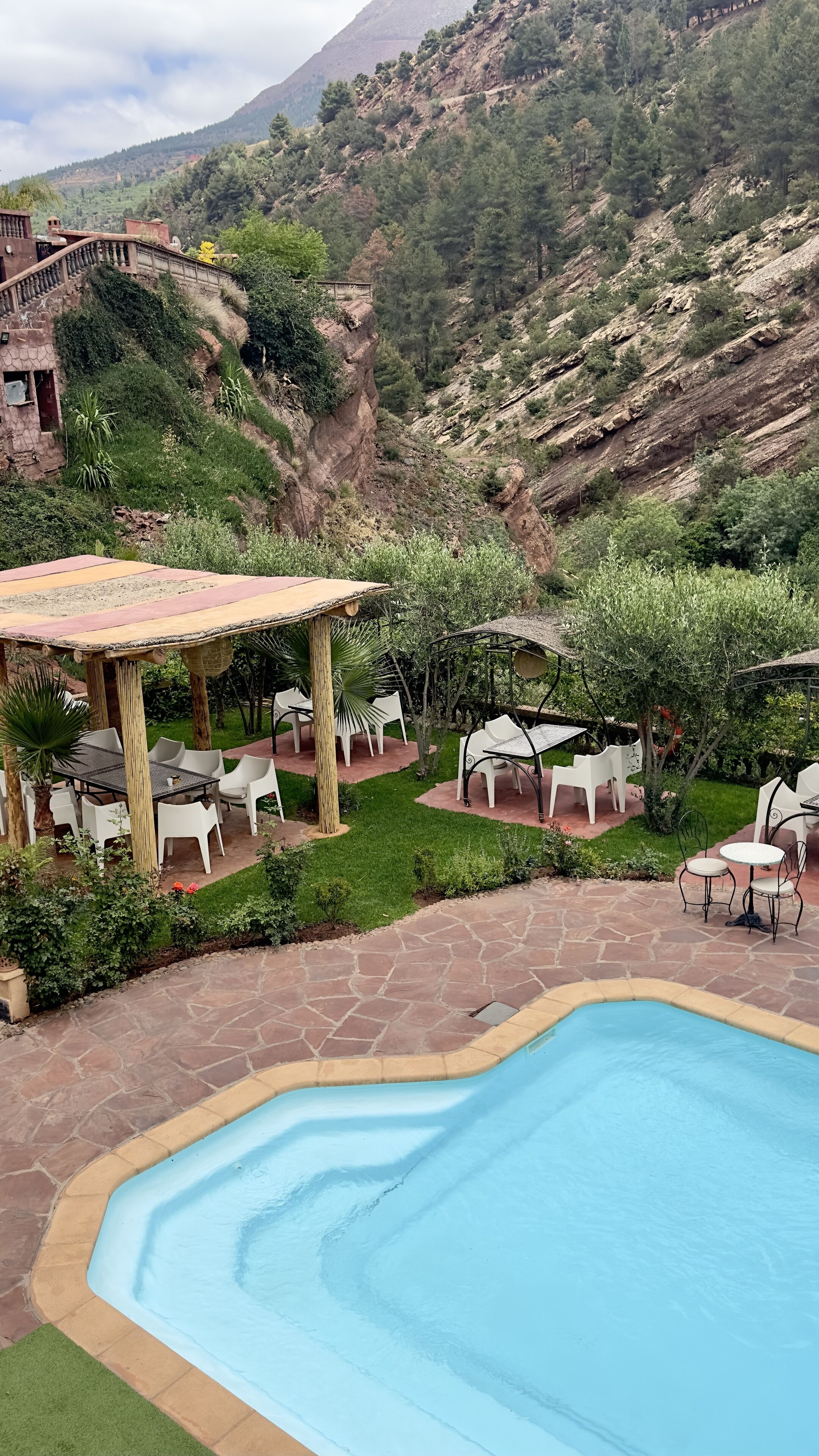 Ein Poolbereich mit Pergola und Sitzgelegenheiten im Freien.