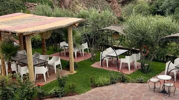 Un área de piscina con una pérgola y mobiliario exterior.