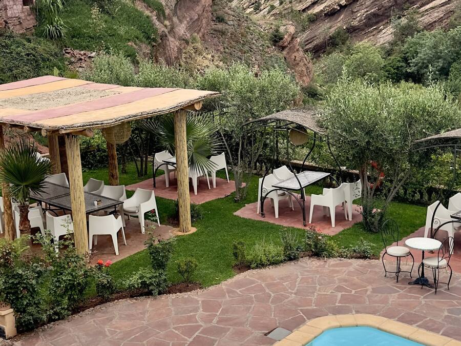 Un área de piscina con una pérgola y mobiliario exterior.