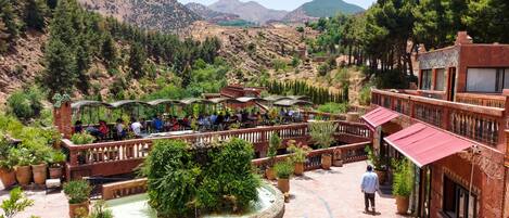 A courtyard with outdoor seating, a fountain, and potted plants.