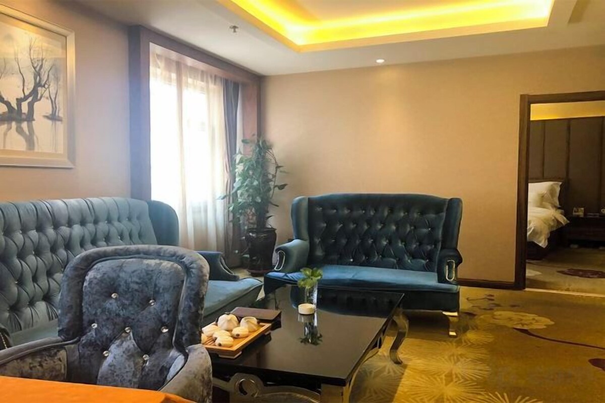 A living room with a sofa, armchair, and a coffee table with a tray of snacks.
