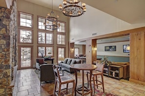 Relax in this inviting space with a round table, sofa, and armchair, plus a TV and a cabinet.