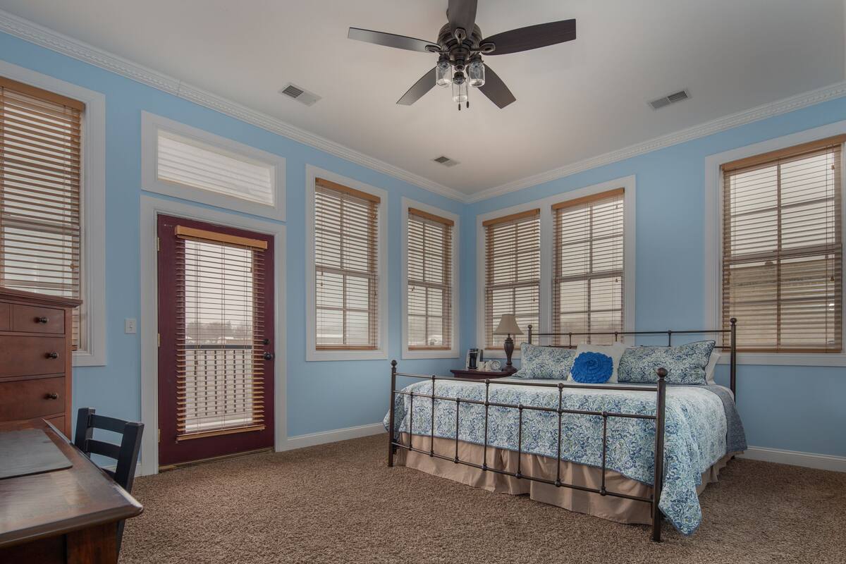 A bedroom with a bed, a desk, and a chair.