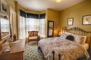 A bedroom with a bed, a chair, a desk, and a mirror. - Crosby House (Astoria)