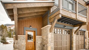 A multi-story building with a stone facade, a wooden entrance door, and a garage with double doors. - River Run Townhome RR42 (Keystone)