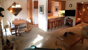 A compact living space with a dining area, kitchen, and seating area. - Standard Condos with Free Parking (Mammoth Lakes)