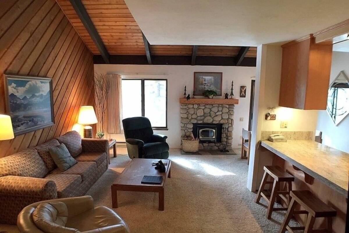 A cozy living room with a fireplace, a sofa, a chair, and a coffee table.